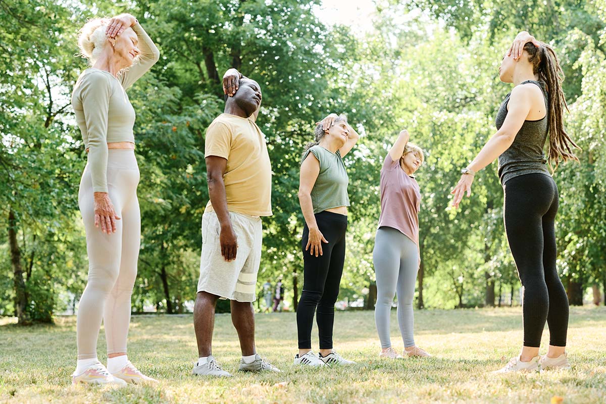 Grupo de pessoas a fazer exercício físico ao ar livre para melhorar a qualidade do sono